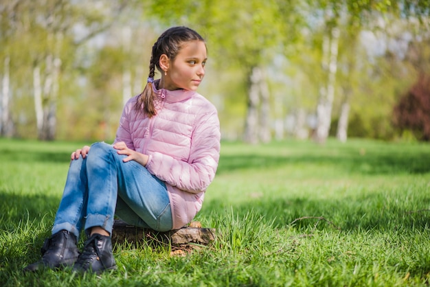 Meisje zit aan de kant in het park kijken