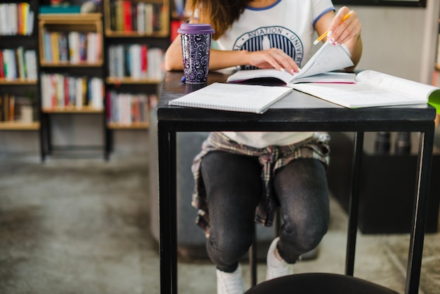 Gratis foto meisje zit aan tafel lezen