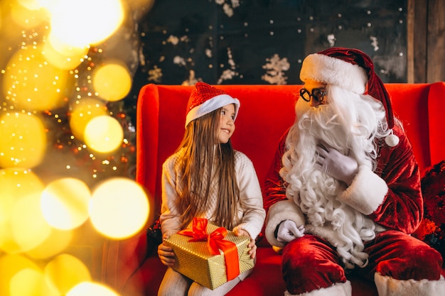 Meisje, zittend met santa en presenteert op Kerstmis