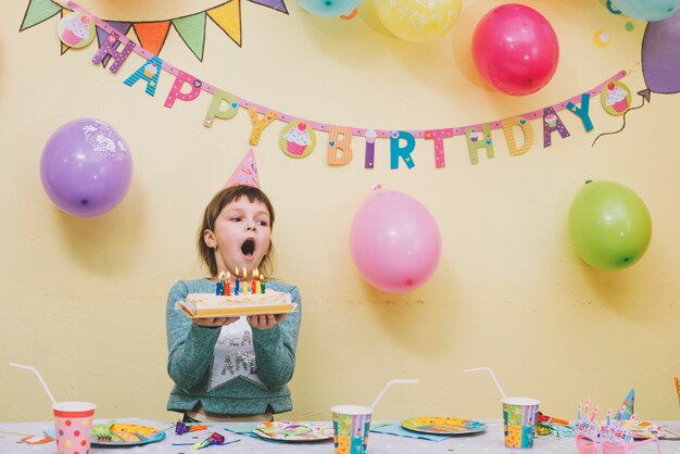 Meisjes blazende kaarsen op verjaardagscake