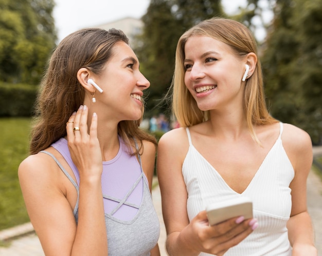 Meisjes die airpods in het park dragen