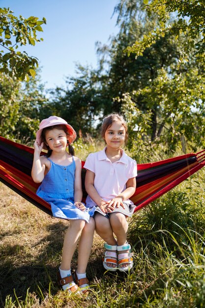 Meisjes die samen buiten spelen en in een hangmat zitten