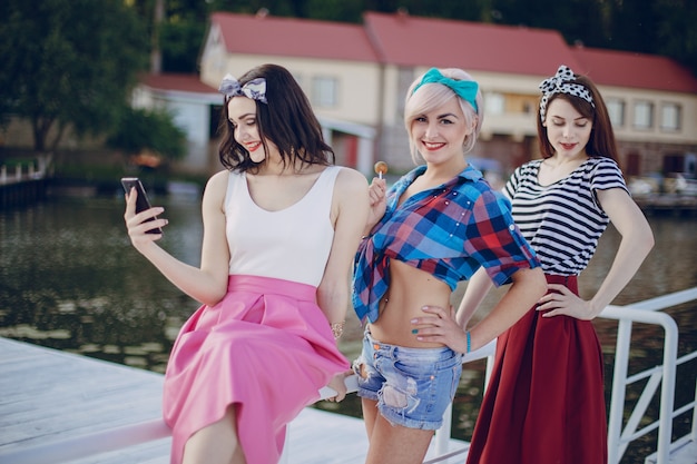 Meisjes die zich voordeed op een witte balustrade en te kijken naar haar mobiele telefoon