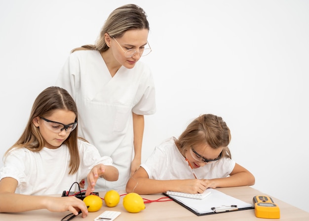 Meisjes doen wetenschappelijke experimenten met citroenen en elektriciteit