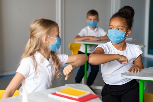 Gratis foto meisjes elleboog stoten in de klas