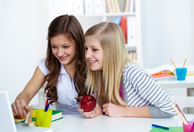 Meisjes lachen met laptop voor het ontbijt