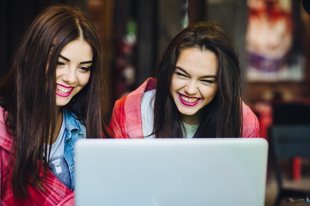 Meisjes lachen terwijl ze kijken naar een laptop