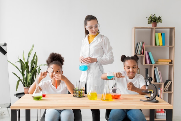 Gratis foto meisjes leren over wetenschap van vrouwelijke wetenschapper