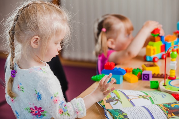 Meisjes met boek en kleurrijk speelgoed