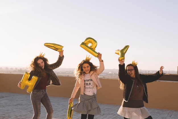 Gratis foto meisjes met plezier met brief ballonnen