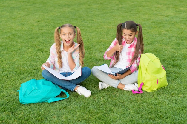 Meisjes scholieren huiswerk samen op frisse lucht, zomervakantie concept. Premium Foto