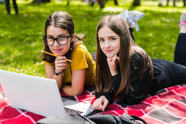 Gratis foto meisjes studeren en poseren op het gras