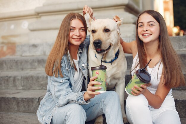 Meisjes zitten op een trap met schattige hond