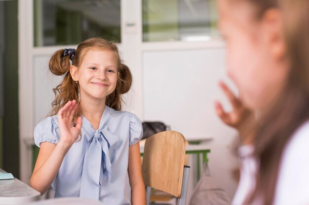 Meisjes zwaaien naar elkaar terwijl ze de sociale afstand bewaren