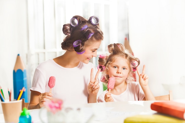 Meisjezitting met haar moeder en het eten van roomijs