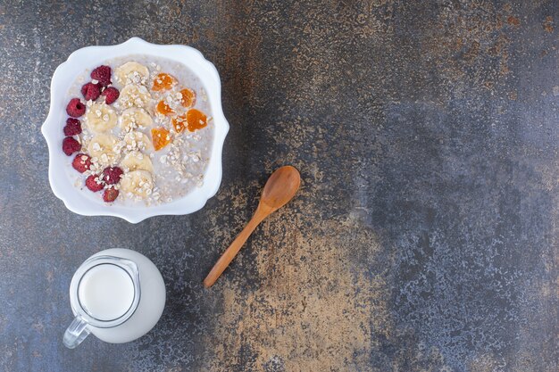 Melkachtige pap met fruit, bessen en een kopje drank