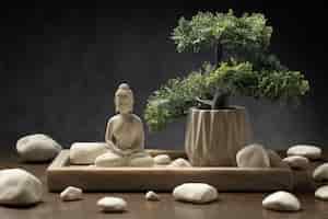 Gratis foto mening van het beeldje van boedha met bonsaiboom