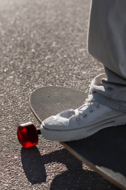 Gratis foto mening van persoon die skateboard met wielen in openlucht gebruikt