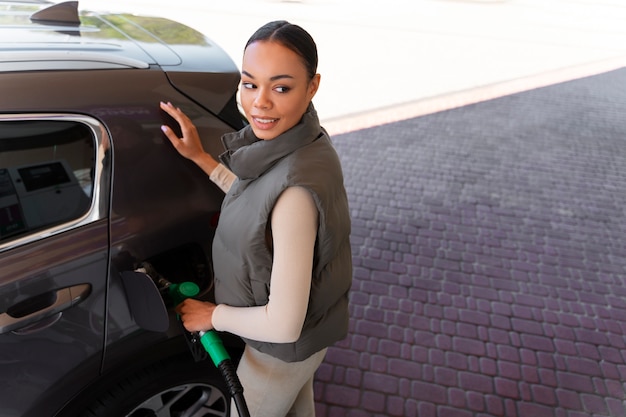 Gratis foto mening van vrouw met auto bij het benzinestation