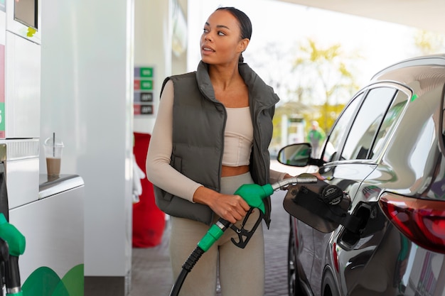 Gratis foto mening van vrouw met auto bij het benzinestation