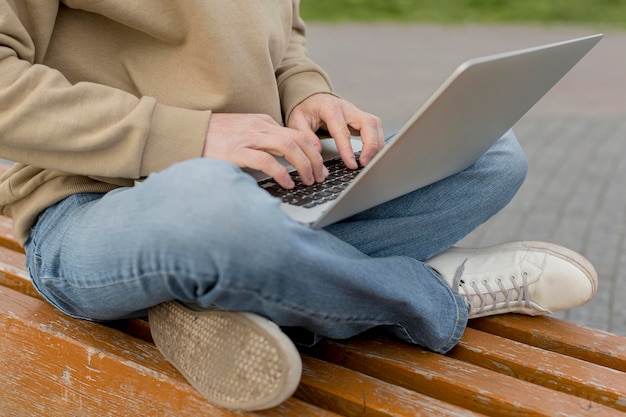 Mens die aan laptop in openlucht in de stad werkt