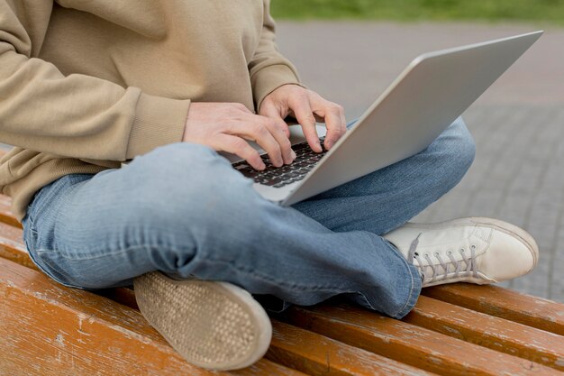 Mens die aan laptop in openlucht in de stad werkt