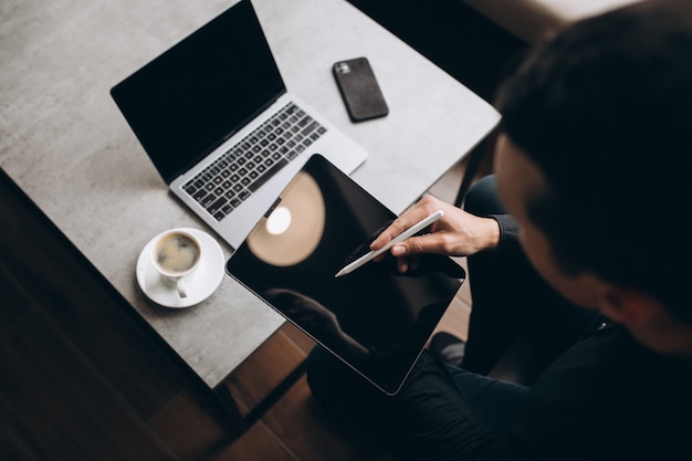 Mens die aan tablet dicht bij de lijst werken