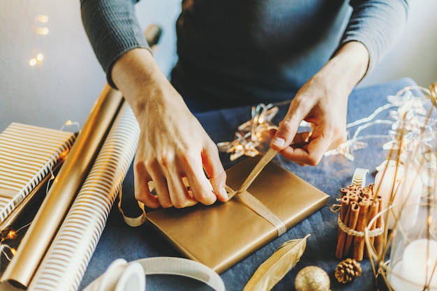 Mens die boog van lint op gift maakt