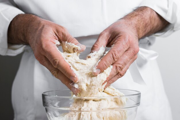 Mens die deeg van kom voor brood vooraanzicht maakt