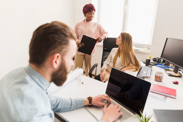 Mens die dichtbij sprekende collega&#39;s werken