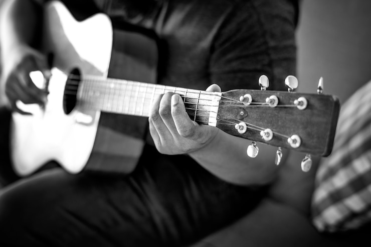 Gratis Foto mens die een akoestische gitaar speelt
