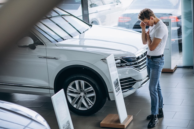 Mens die een auto in een autotoonzaal zoekt