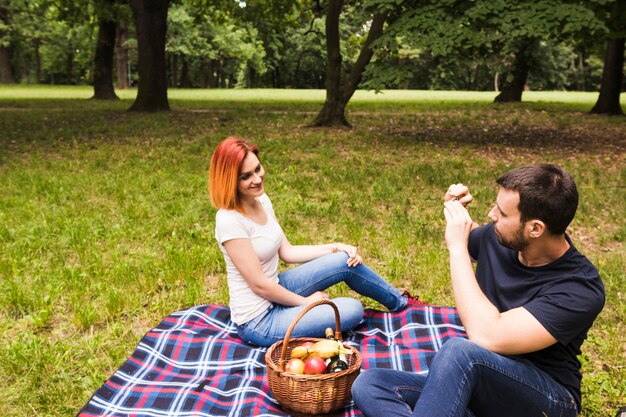Mens die foto van haar meisje op celtelefoon neemt bij picknick