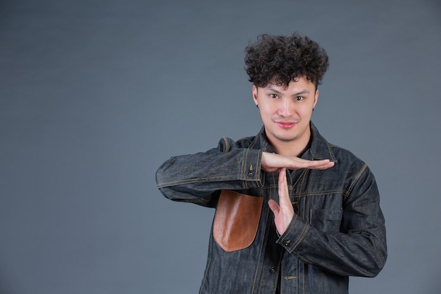 Mens die handgebaar in studio achter het stellen toont