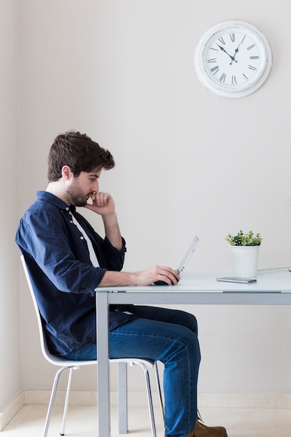 Mens die laptop en het denken met behulp van