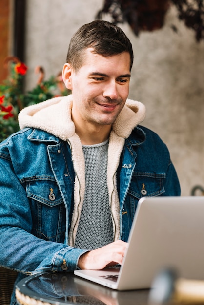 Mens die laptop in stedelijke omgeving met behulp van