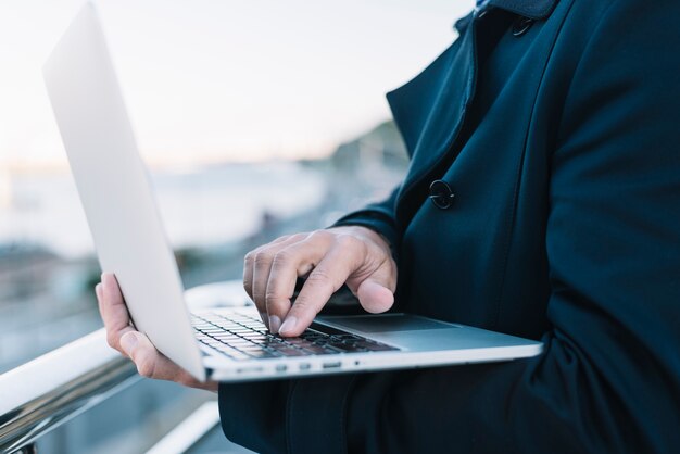 Mens die laptop in stedelijke omgeving met behulp van