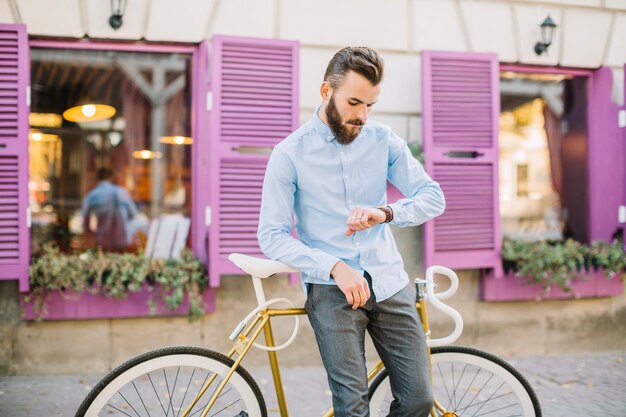 Mens die met fiets horloge bekijkt