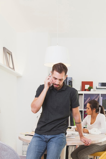 Mens die met smartphone in bureau communiceren