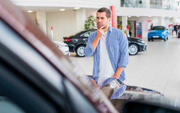 Gratis foto mens die nieuwe auto controleert