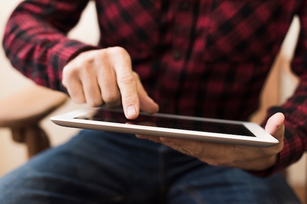 Mens die op een tabletclose-up kijkt