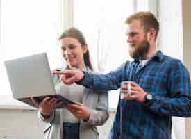 Gratis foto mens die op laptop greep door zijn vrouwelijke collega richt