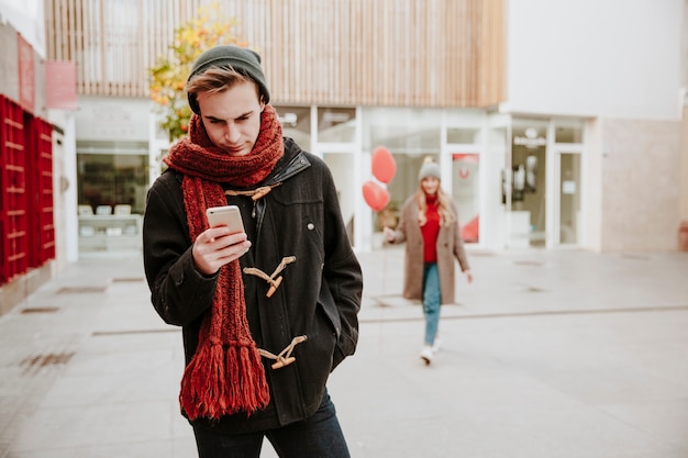 Mens die op meisje met smartphone wacht