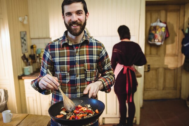 Mens die voedsel in keuken voorbereidt