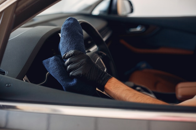 Mens die zijn auto in een garage wast