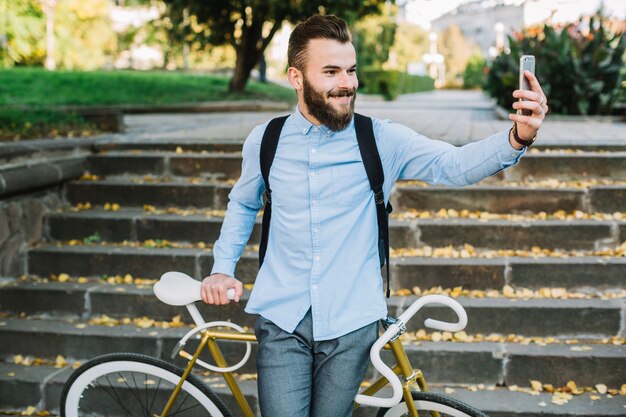 Mens met fiets die selfie dichtbij treden nemen