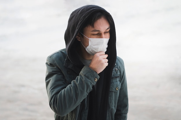 Mens met medisch masker dat buiten stelt