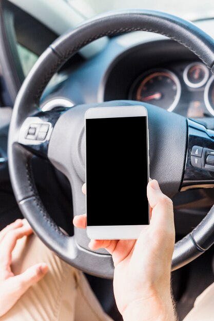 Mens met smartphone in auto