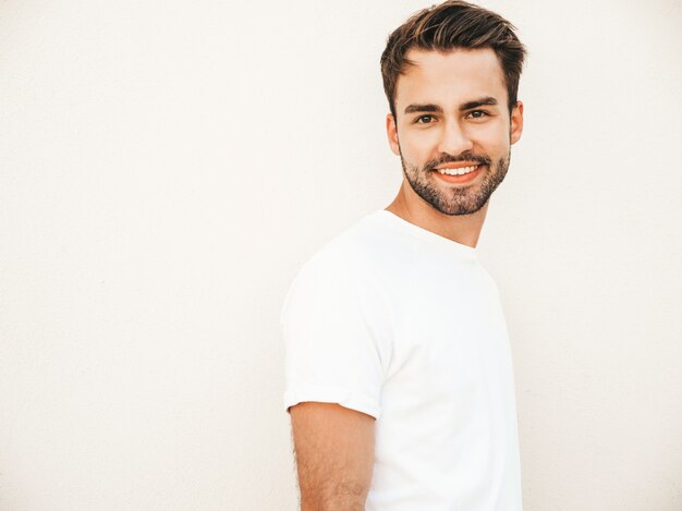 Mens met zonnebril die het witte t-shirt stellen dragen