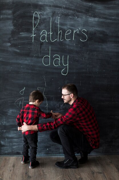 Mens met zoon op vadersdag voor bord